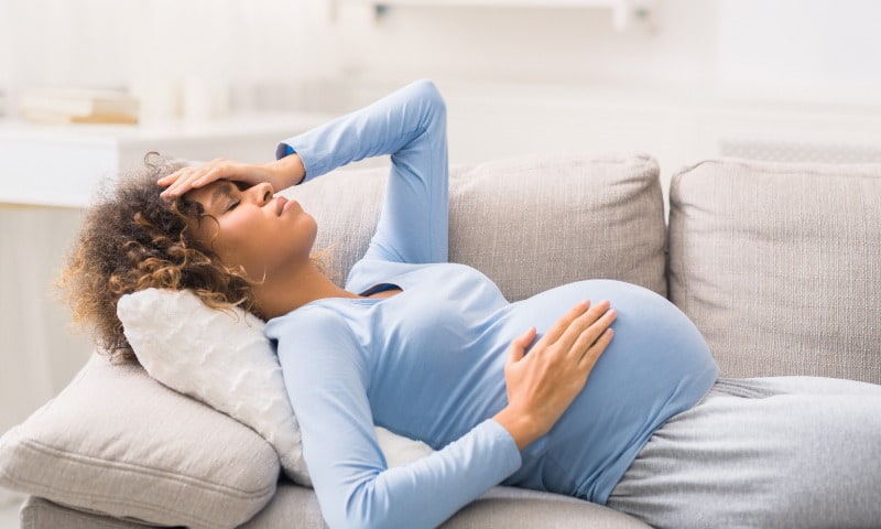 Femme enceinte qui se tient la tête 